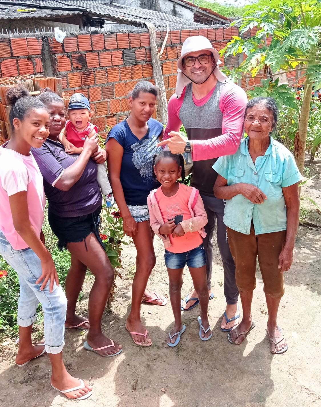 Grupo de adultos e crianças reunidos ao ar livre