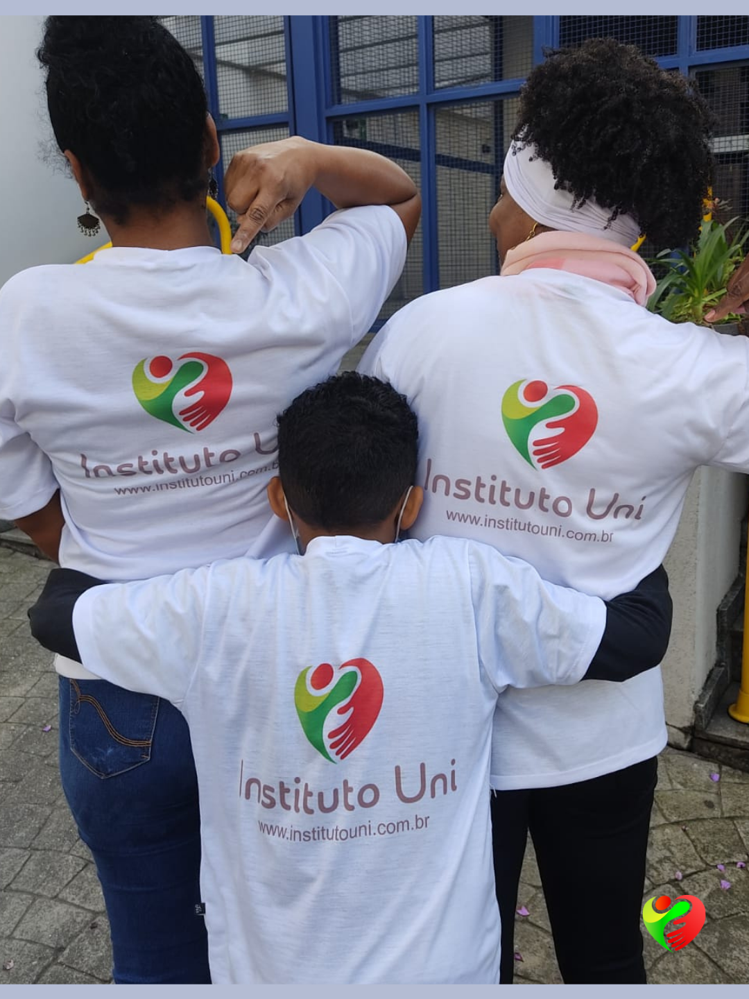 Adultos e criança vestindo camisetas do Instituto Uni